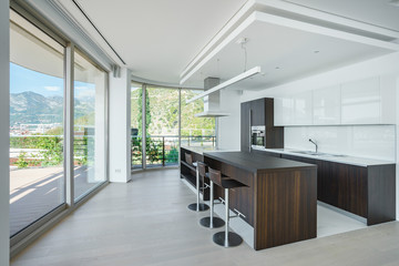 Interior of light spacious kitchen with large panoramic windows in a luxury villa