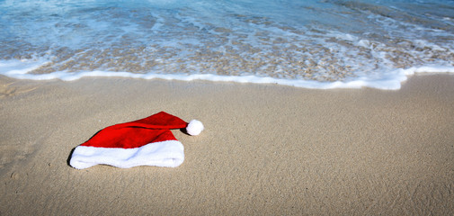 Santa Claus hat on caribbean beach. Christmas background