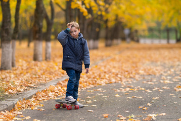 Young boy with skateboard and his hand to forehead