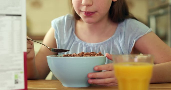 Close Up Of Girl Eating Unhealthy Bowl Of Sugary Breakfast Cereal In Kitchen