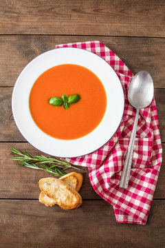 Vegetarian autumn Tomato soup with bread on wooden table, flat lay. Copy space