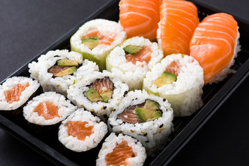 sushi pack with nigiri and maki on black background © chandlervid85