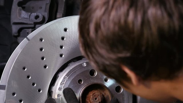 Man installing new car brake disc