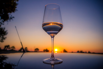 Sunset glass of water on a car roof