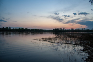 colorful sunset on the lake with water reflections and dramatic storm clouds above