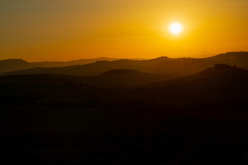 Amazing sunset in Tuscany, Italy, Europe. Beautiful landscape with sunset among the tuscan hills..