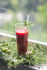 Strawberry smoothie drink on green grass