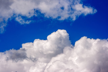 Naklejka na ściany i meble lush white cumulus clouds swim across the blue sky