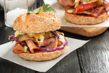 Sandwiches with fried bacon ,vegetables and fried egg on wooden board