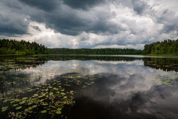 colorful sunset on the lake with water reflections and dramatic storm clouds above