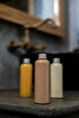 Spa cosmetics in plastic bottles on dark gray concrete table, bathroom interior. Beauty blogger, salon therapy, branding mockup, package, minimalism concept