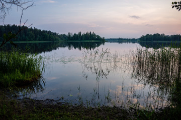 colorful sunset on the lake with water reflections and dramatic storm clouds above