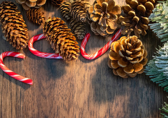 Christmas wooden background with wreath, pine cones and candy canes with copy space