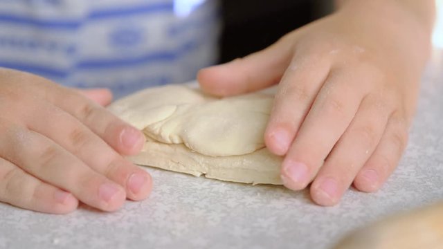 Children's rolling pin for dough. The child kneads the dough with his hands.