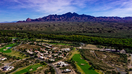 Fototapeta na wymiar Aerial, drone view of Tubac, Arizona with blue sky, green flora including palo verde trees, purple mountains