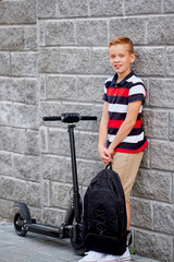School boy in standing with his electric scooter in the city with backpack © glazunoff