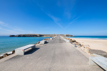 Fototapeta na wymiar asphalt road and breakwaters to Isla Palomas, Pigeon Island, from Tarifa town in Cadiz (Andalusia, Spain, Europe). In fact, is an isthmus