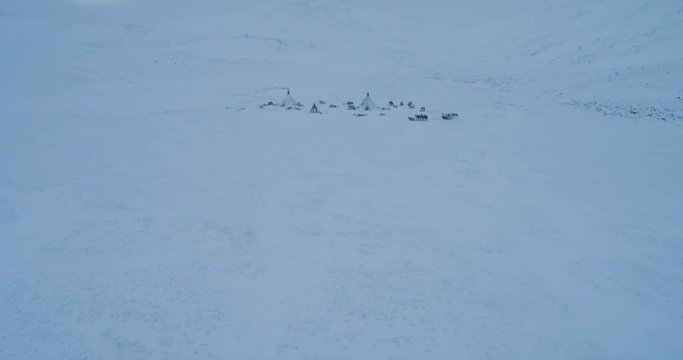 Drone capturing video of tundra in Siberia amazing view of yurts camp, how people living in the middle of field full of snow.