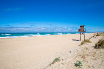 wooden watchtower for lifeguard in Palmar Beach, with sand and turquoise ocean water in Vejer village (Cadiz, Andalusia, Spain)