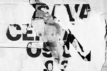 Old grunge ripped torn vintage collage street posters creased crumpled paper surface placard texture background backdrop dark black