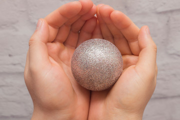Christmas ball in the hands of men