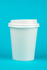 Paper coffee container with white lid on blue background. Take-away beverage container. Drink Cup template for your design