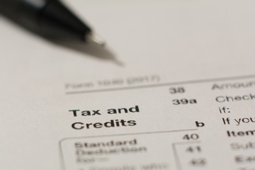 Words "tax and credits" on a paper with pen