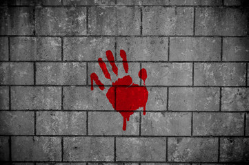 Brick wall with a red palm print