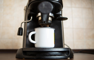 Photo of coffee maker, mug on table