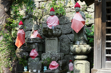 Selective focus buddhist sculptures at Japanese temple and shrine with flowers in vases