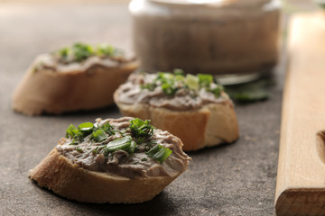 Fresh homemade chicken liver pate with greens on bread on a dark background. A sandwich. close-up