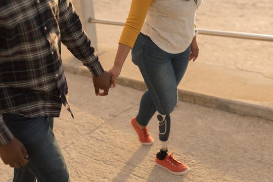 Couple holding hands and walking on promenade