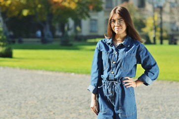Young beautiful student is wearing glasses on the background of the Park