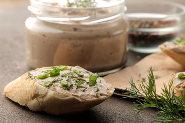 Fresh homemade chicken liver pate with greens on bread on a dark background. A sandwich. close-up