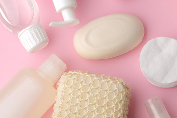 Body and skin care products in white packaging on a pink delicate background. Personal hygiene products. View from above. Flat lay
