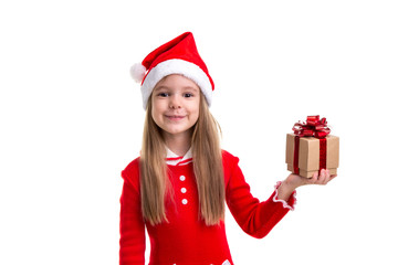 Happy christmas girl holding a gift it in the left hand, wearing a santa hat isolated over a white background