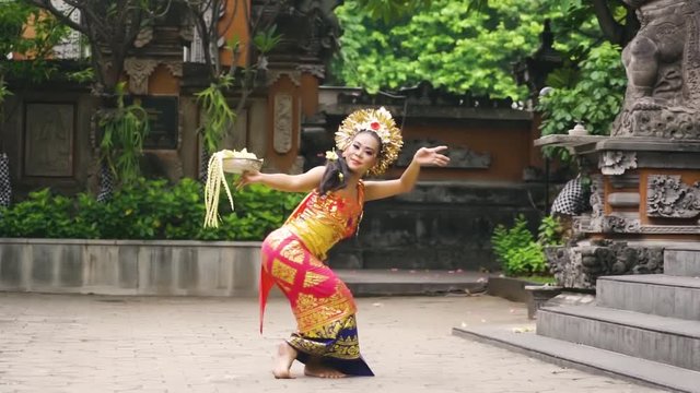 Balinese female dancer performing artistic dance in colorful costume. Shot in 4K in Bali, Indonesia 