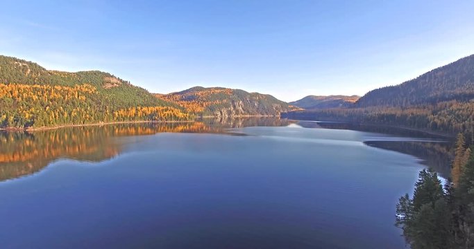 Aerial shot of a Drone flying in and out of shot on a Lake in Montana in the Fall or Autumn