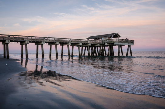 Wide angle view of the Tybee Island Pier in Georgia. Colorful sunset with pinks and purple colors in the sky