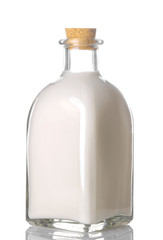 Fresh milk in a glass bottle close-up on a white isolated background.