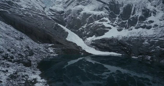 Flying above glacier lake in Olden and revealing Briksdalsbre glacier, Norway, Aerial shot