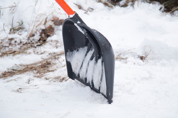 Clearing snow with a shovel in the winter on the street