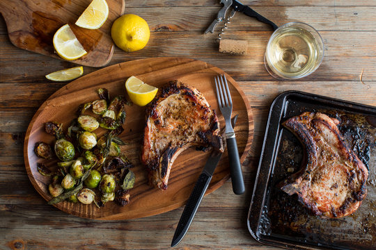 Overhead view of pork chop with brussels sprout served on plate