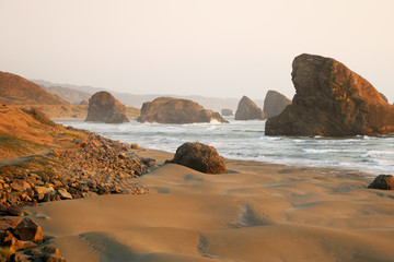 Fototapeta na wymiar Sandy beach of the Pacific coast with rocks