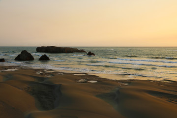 Sandy beach of the Pacific coast with rocks