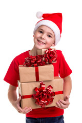 Handsome happy boy, santa hat on his head, with bunch of the gift boxes in the hands. Concept: christmas or Happy New Year holiday