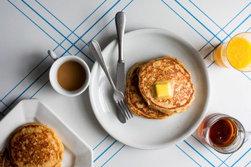 Overhead view of whole grain pancakes served with butter on plate