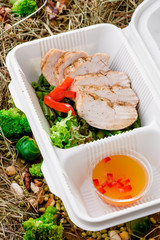 Slices of chicken gruel with fresh vegetables. Healthy food delivery. Take away for diet. Fitness nutrition, vegetables, meat and fruits in eco boxes. at wood and straw with copy space.