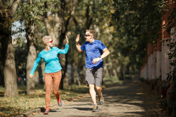 Fototapeta premium Photo of sporting man and woman doing handshake on morning jog