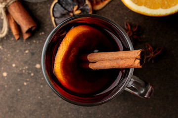 Hot mulled wine with cinnamon and orange in glass cups close-up on a dark background. View from above. Christmas. new Year.